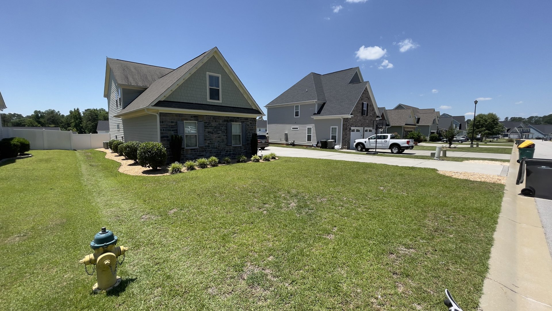A craftsman home with a maintained lawn and the Transitions truck on the street